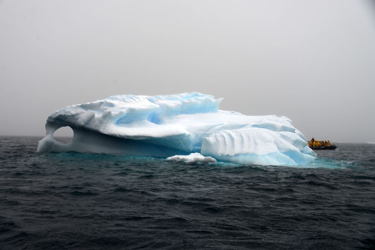 05A Zodiac With Iceberg With A Window In Foyn Harbour On Quark Expeditions Antarctica Cruise